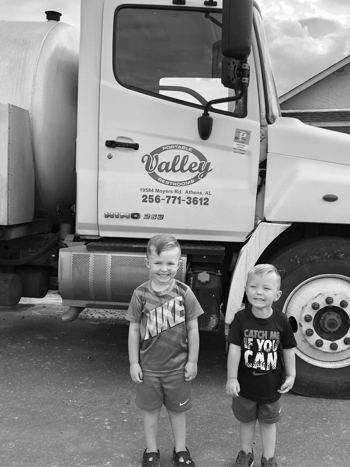 Greg Polson's grandsons standing in front of a Valley Portable Restrooms service truck